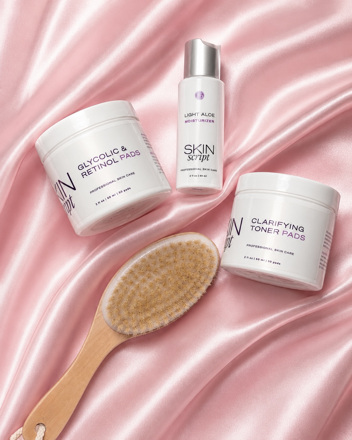 Skin Script Rx aftercare products and a dry brush on pink satin